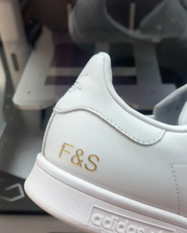 Initiales F&S gravées au laser sur le talon d'une sneaker blanche