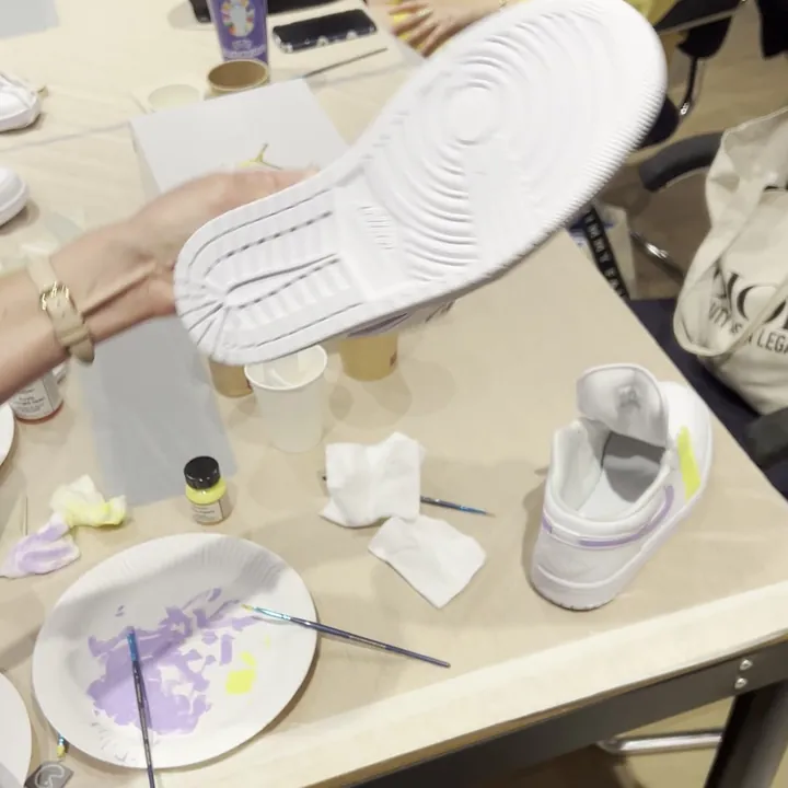 Peintures, pinceaux et sneaker retournée pendant un atelier