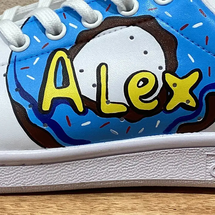 Gros plan d'un prénom peint à la main sur une Stan Smith